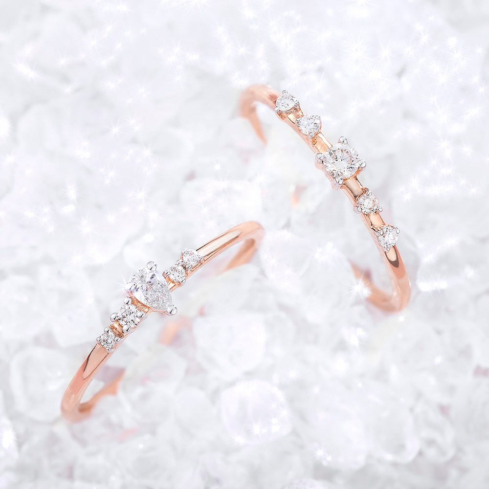 Dva zlatna prstena u gomili neobrušenih dijamanata.