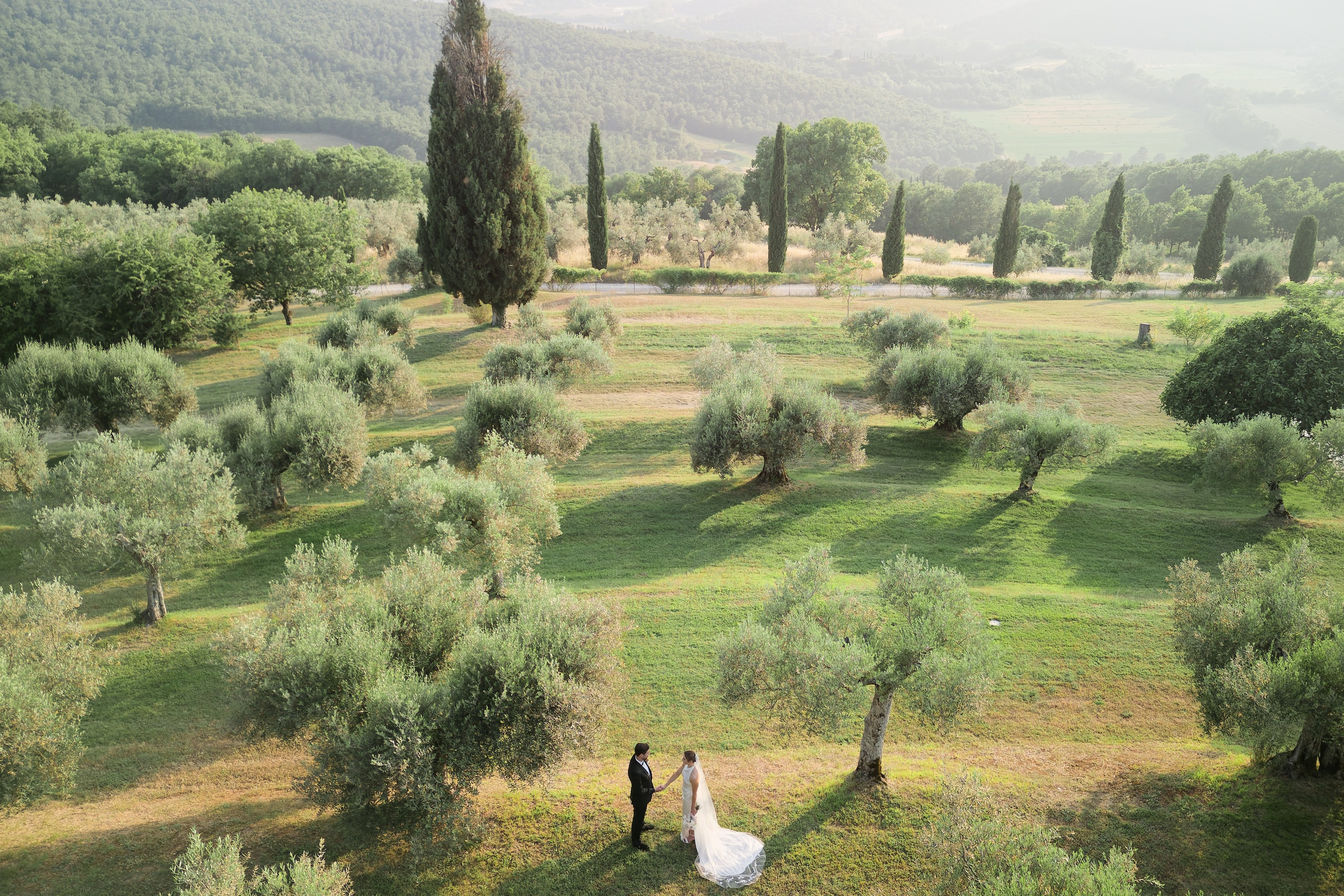 Eine Braut und ein Bräutigam umarmen sich vor einem See.
