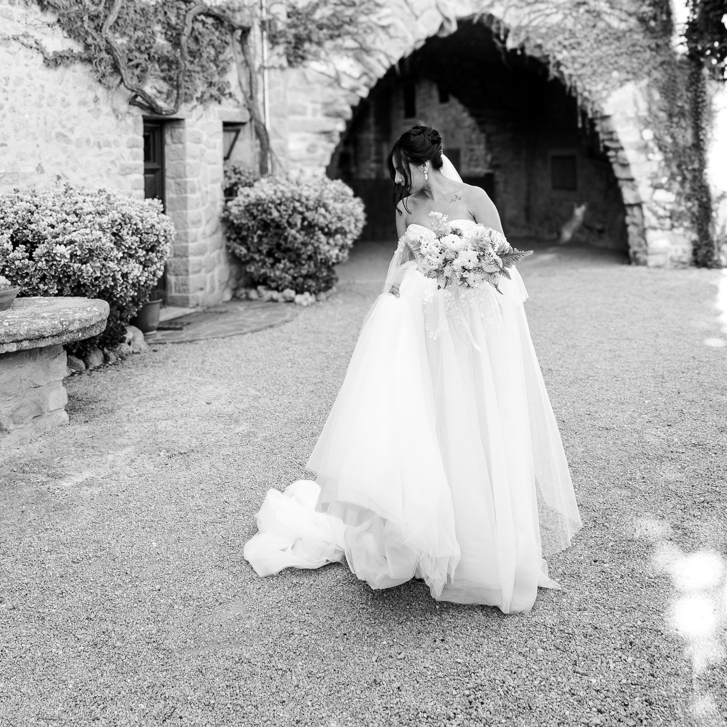 Bride twirling in her gown under La Baronia’s arched balcony