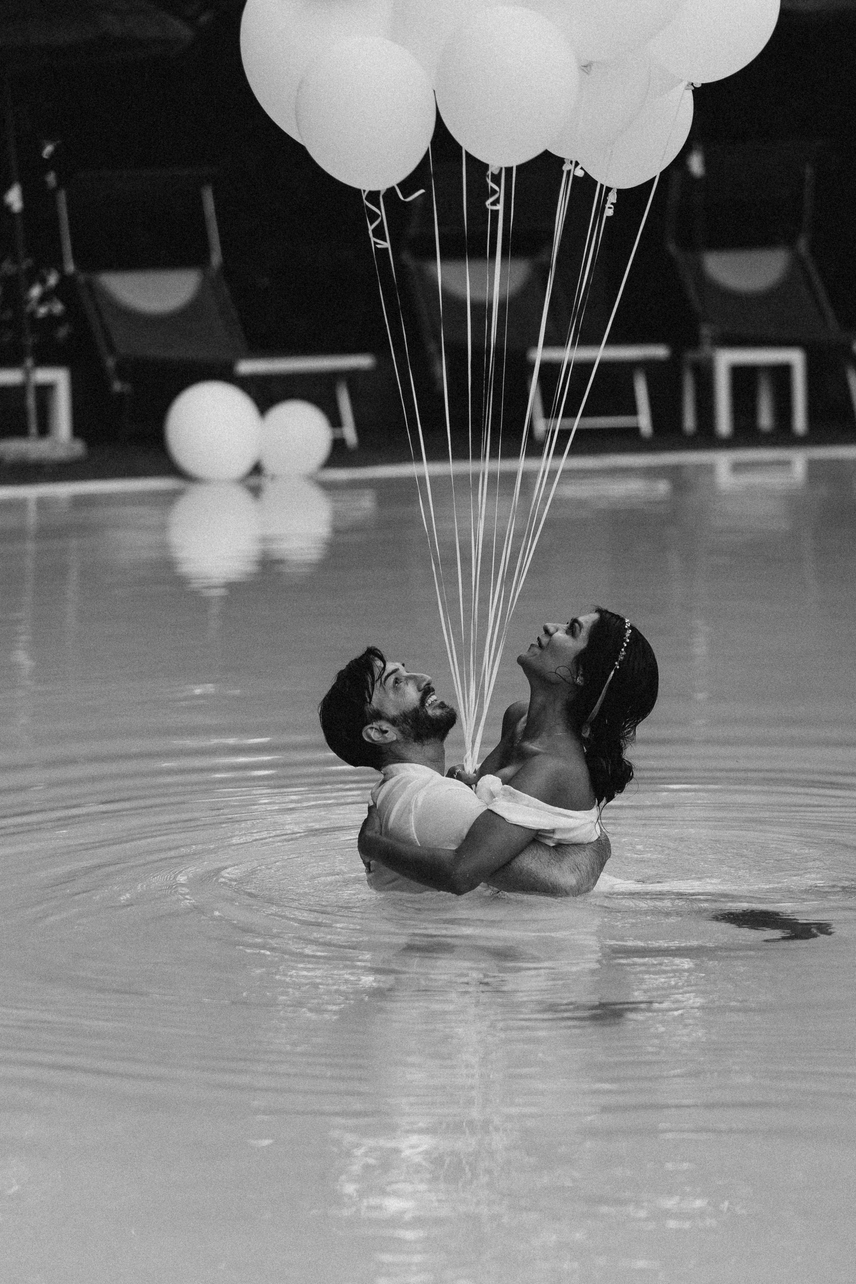 Luxury photoshoot with white baloons in a swimming pool on the lake Como
