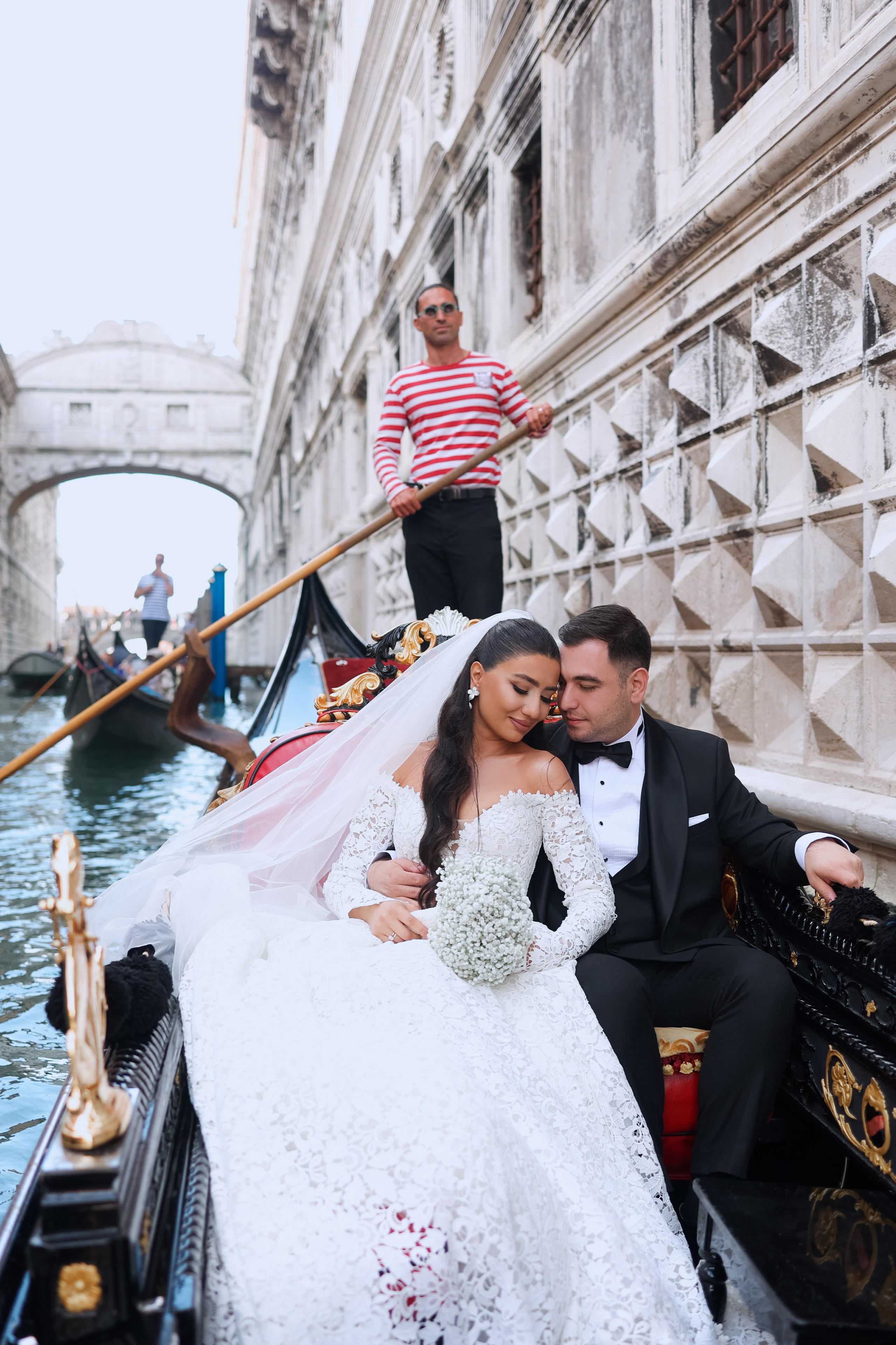 Bride and groom enjoying a romantic gondola ride through the canals of Venice