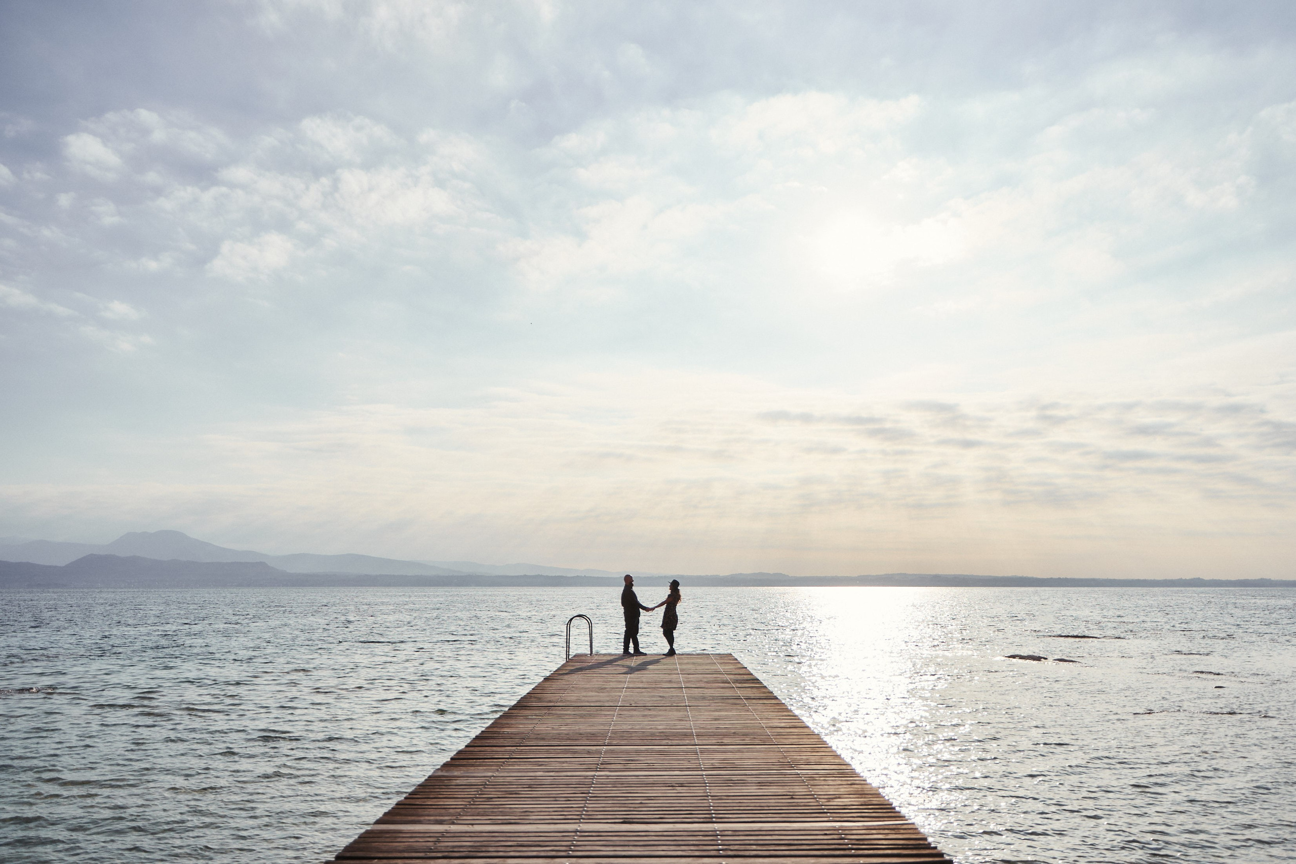 una coppia degli sposi sullo sfondo di lago di Garda e montagna, fotografo di matrimonio
