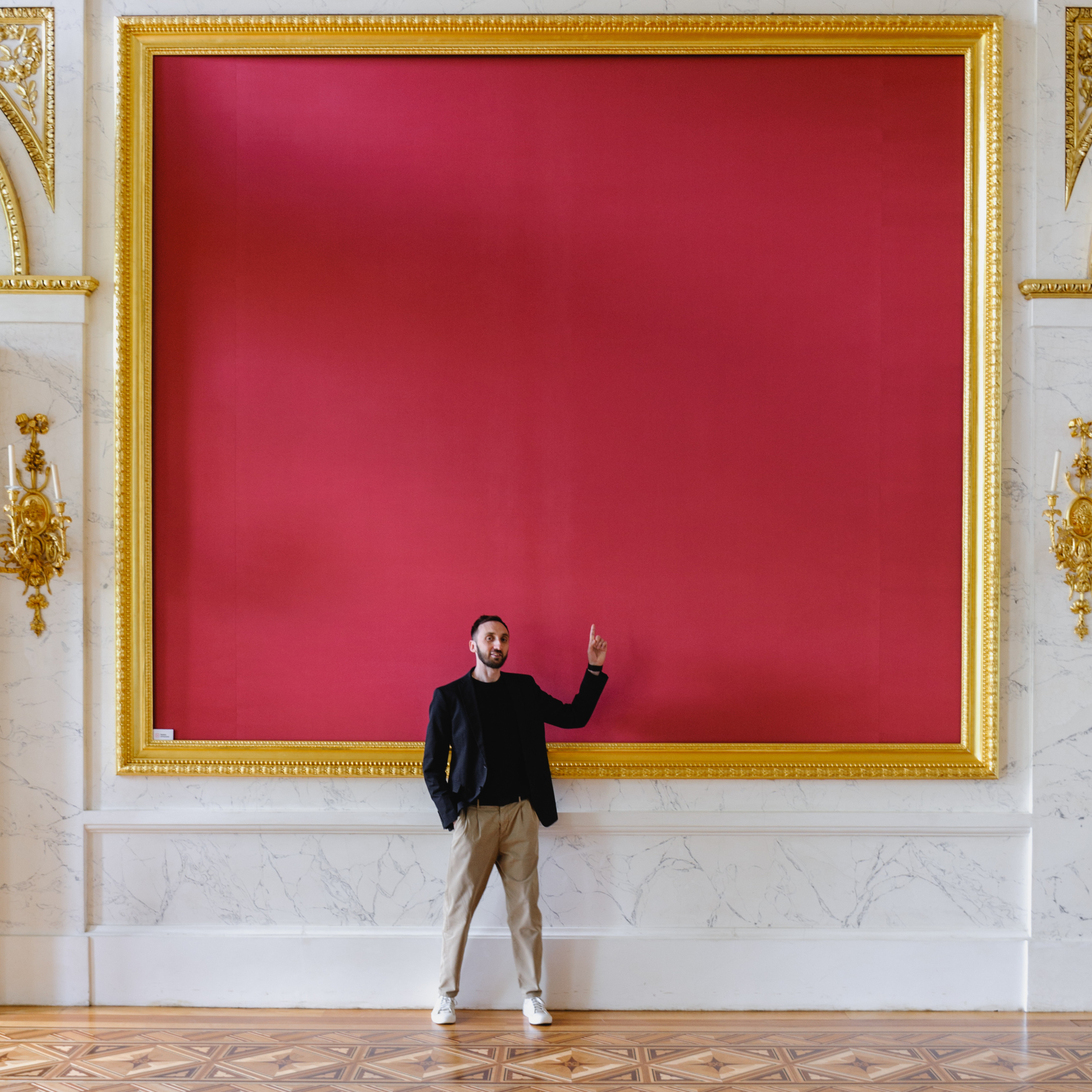 Dmitry Solodkiy points to a huge painting with a solid red canvas. The Royal Baths Museum in Warsaw.