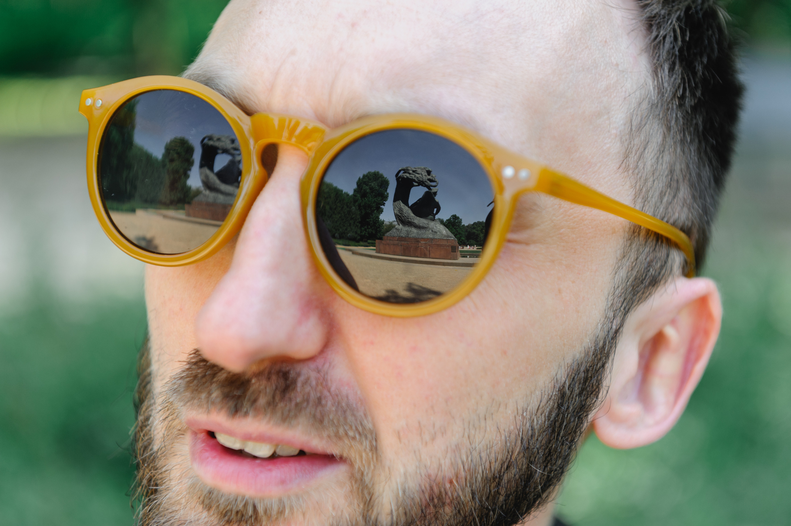 Art historian Dmitry Solodkiy, wearing black glasses, looks at the Chopin monument.