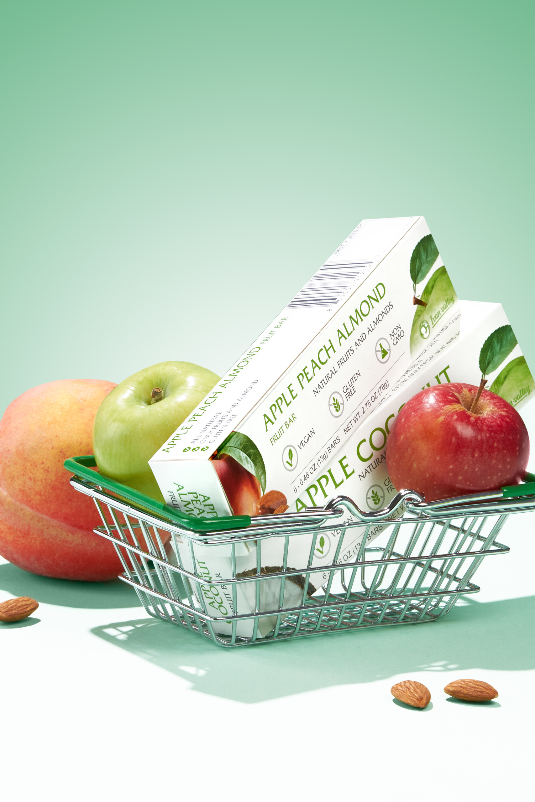 Photographie retouchée de produit de la dentifrice sur un fond vert clair dans un mini chariot de magasin entourée de pommes rouges et vertes, publicité de retoucheur produit