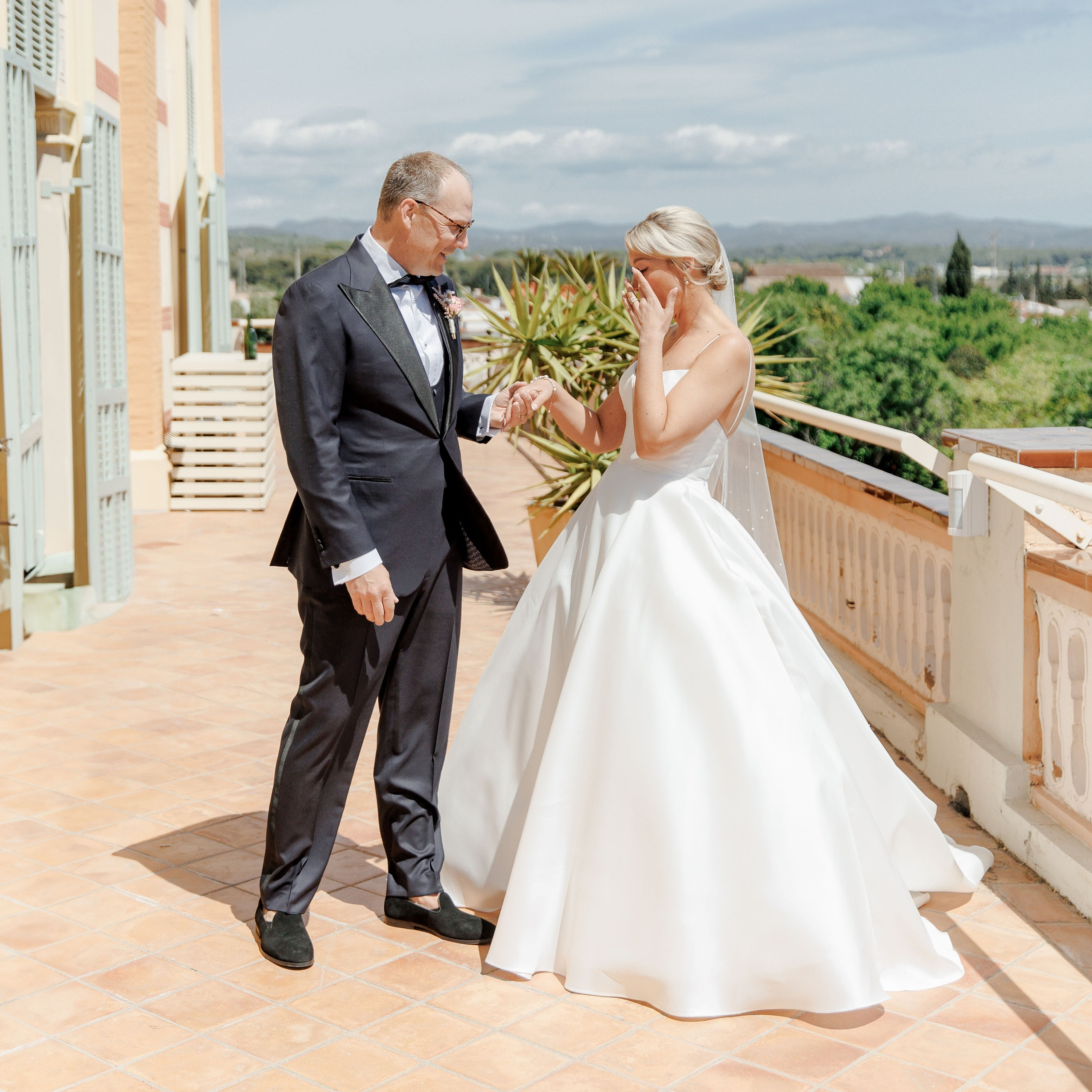 Groom and bride's firs look on a terrace of a wedding venue