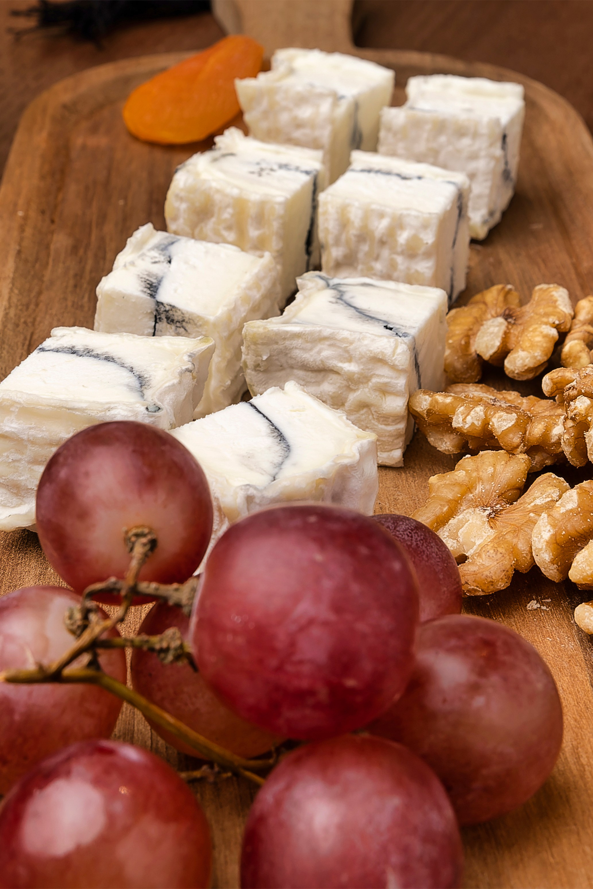 foto de tabla de restaurante con trozos de queso y uvas moradas