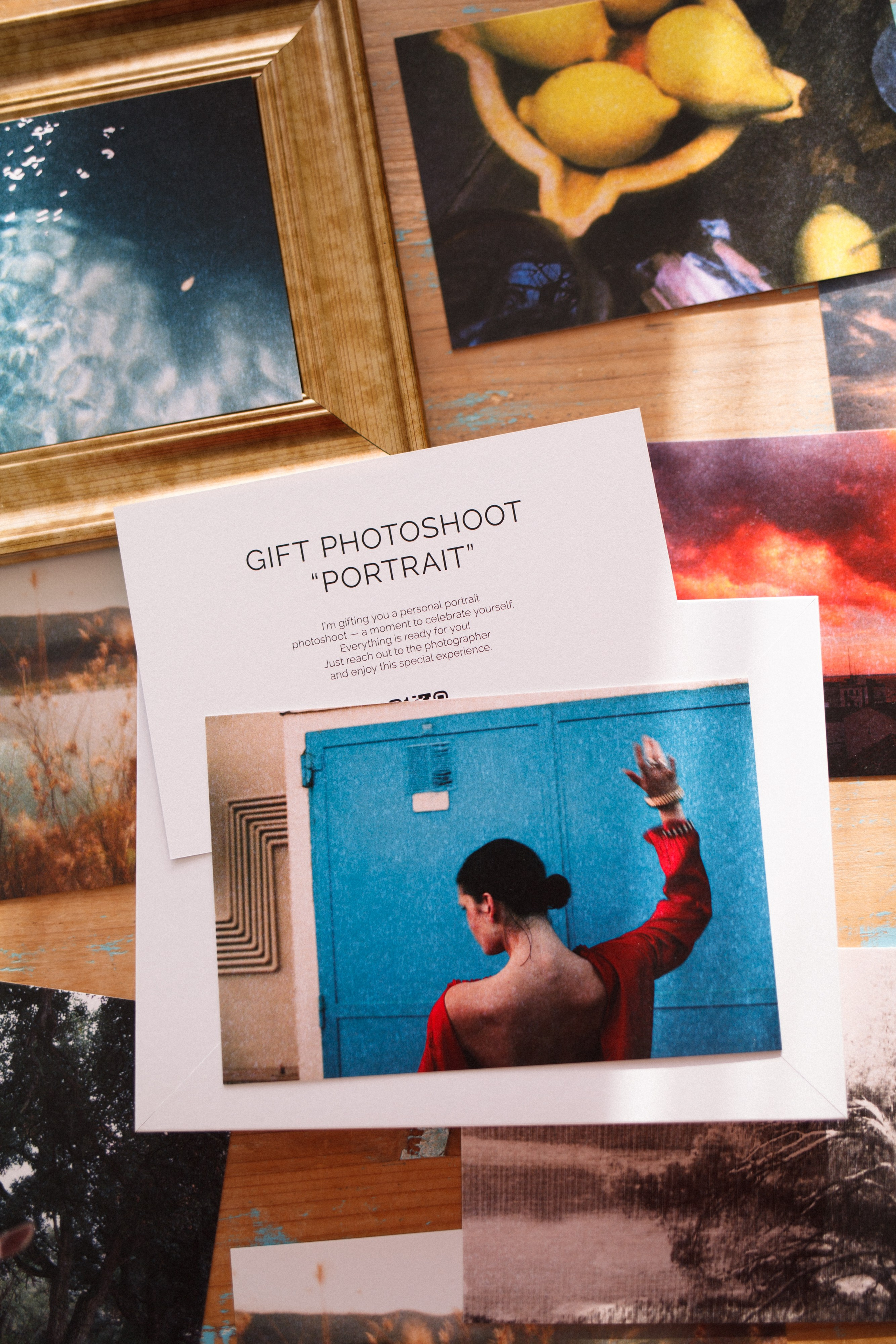 Close-up of printed photos and postcards scattered on a surface, featuring an image of a person in red against a blue background