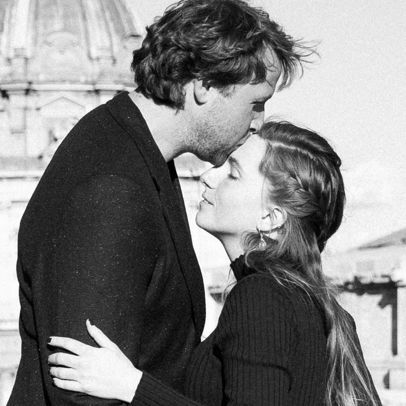 Bride and groom sharing a kiss with the Roman Forum in the background.