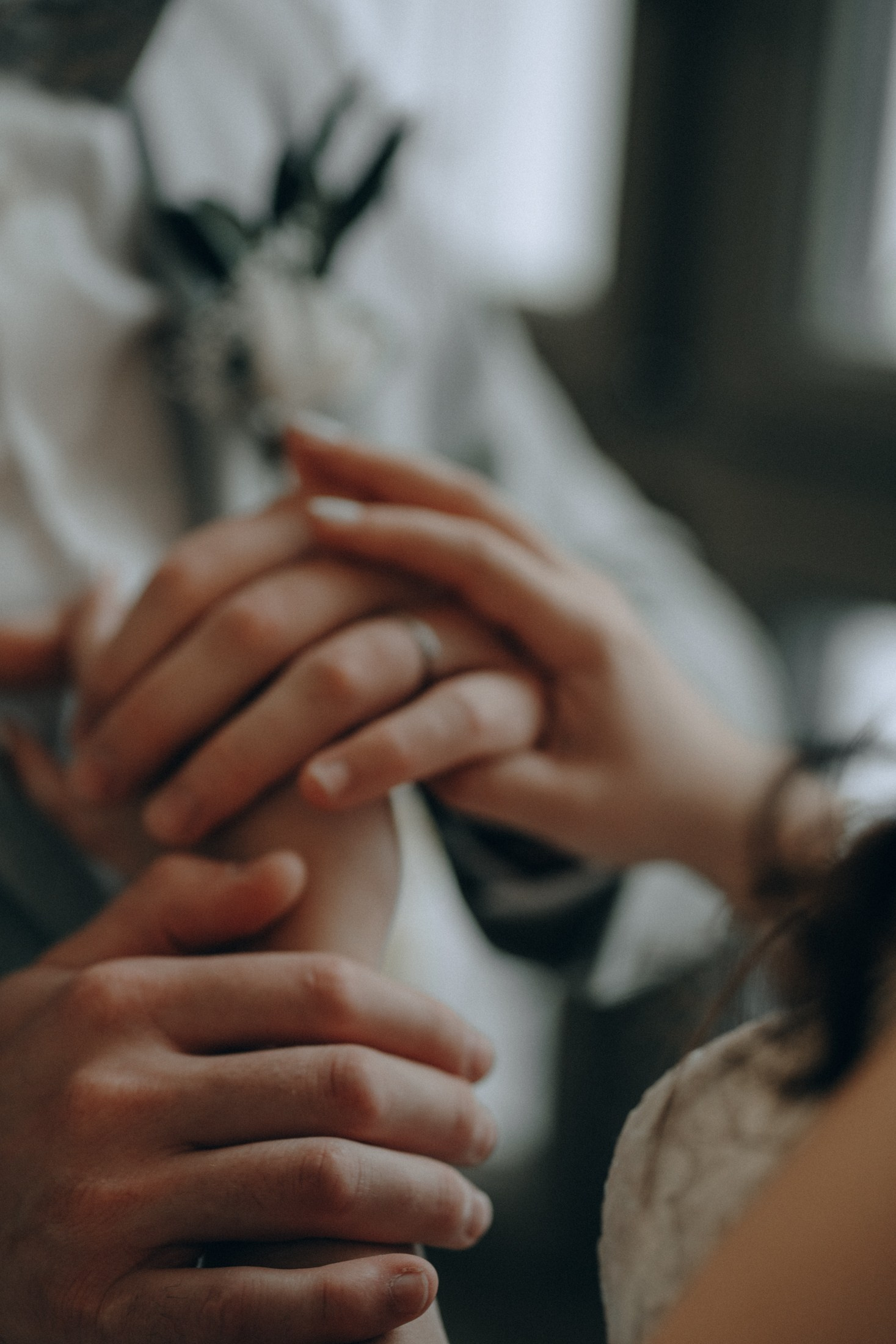 Свадебная съемка — жених и невеста держатся за руки крупным планом