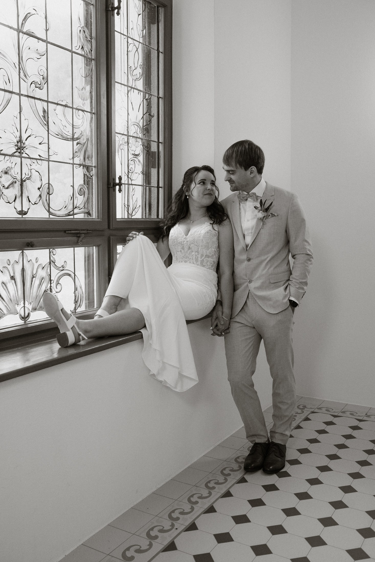 Свадебная фотосессия — жених и невеста у окна в черно-белом