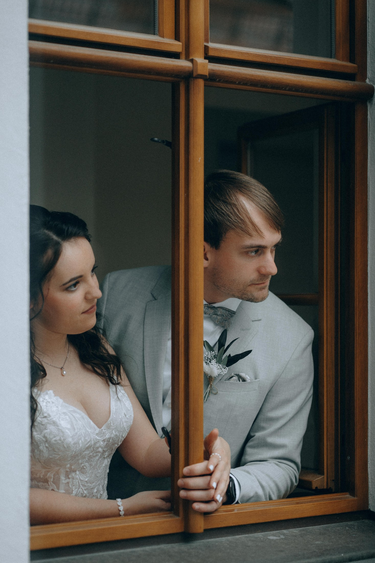 Свадебная фотография — жених и невеста у окна, романтичный момент