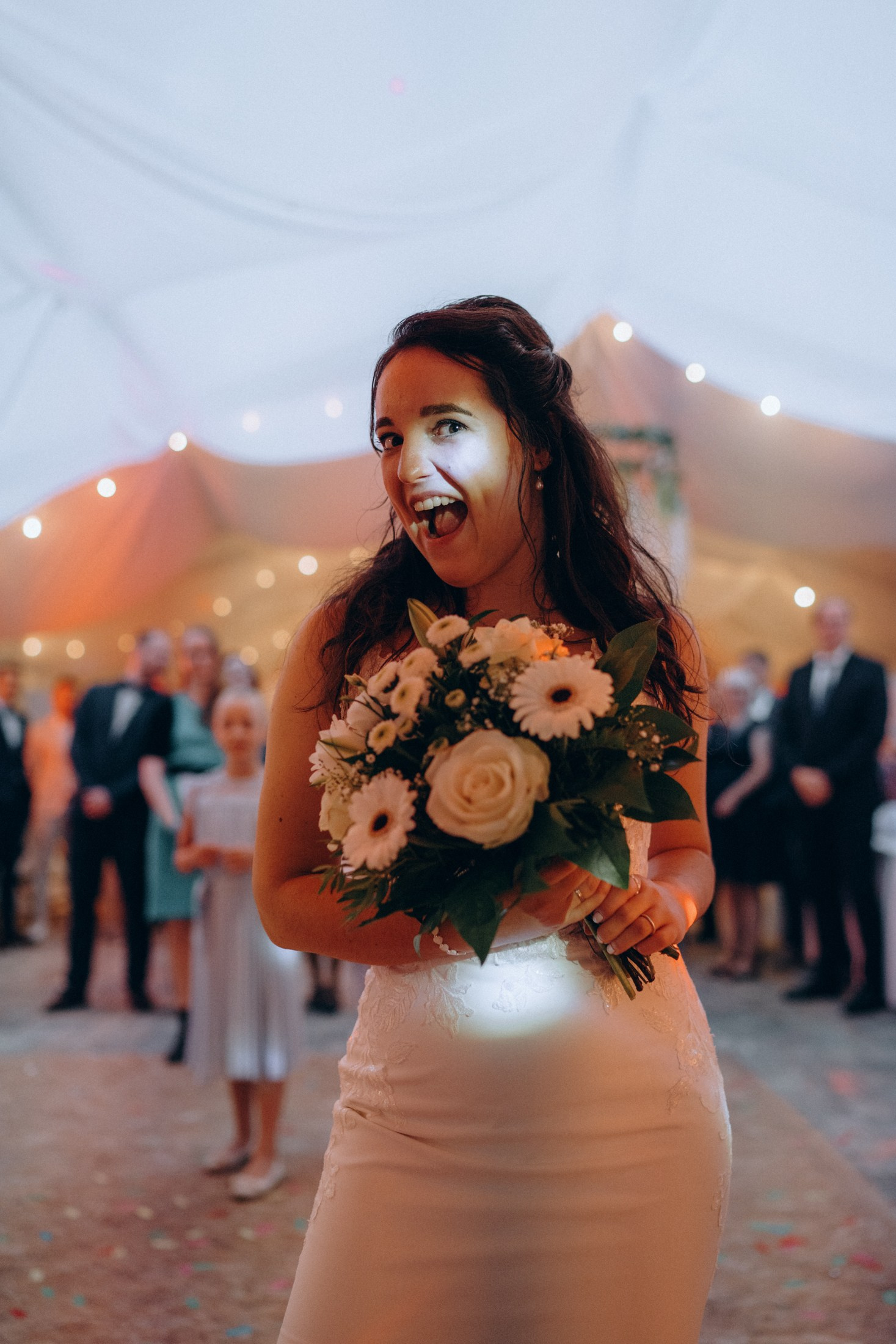 Невеста бросает букет цветов на банкете