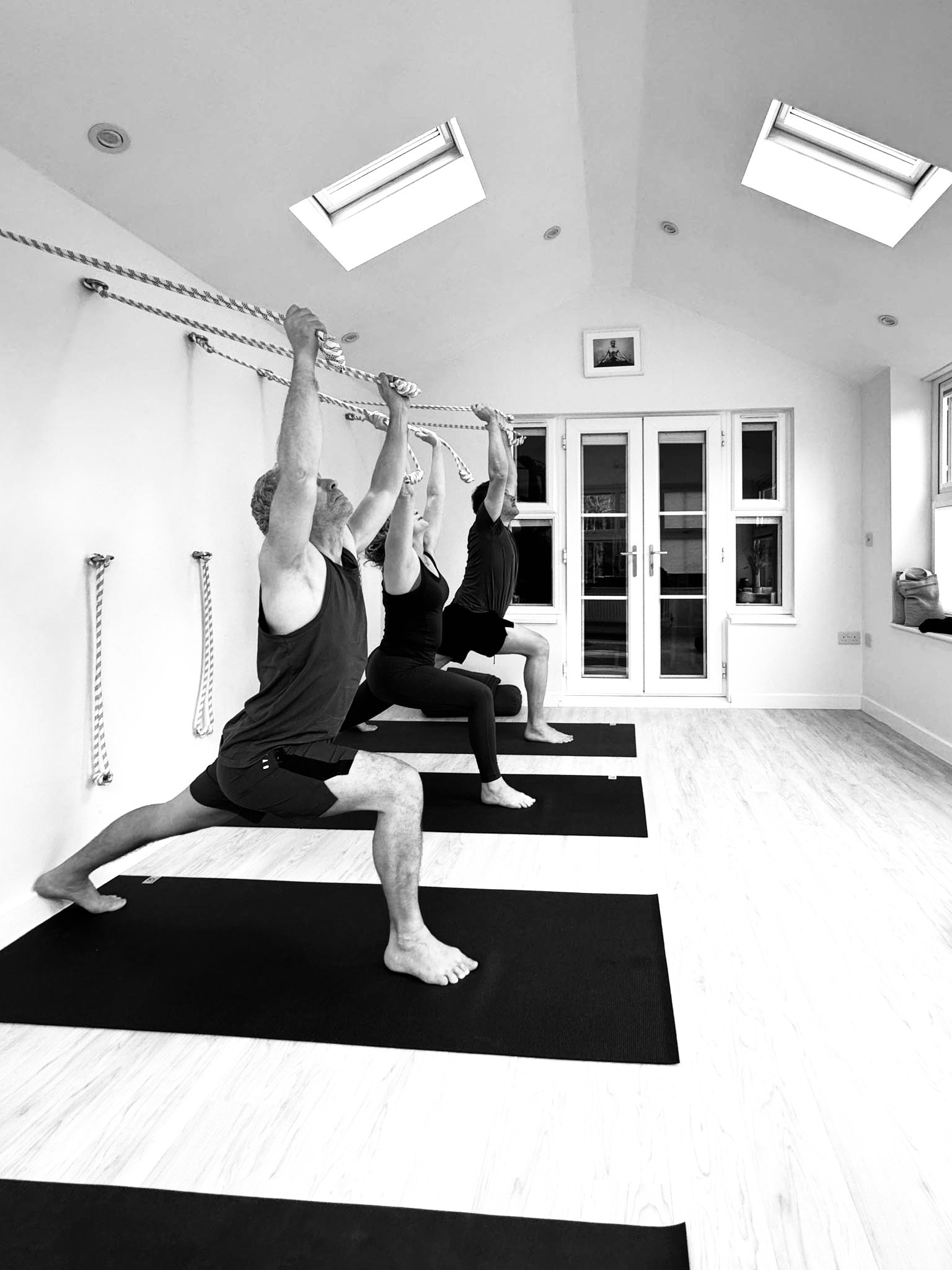 Focused Iyengar yoga practice in Solihull, students receiving hands-on guidance in small class setting.